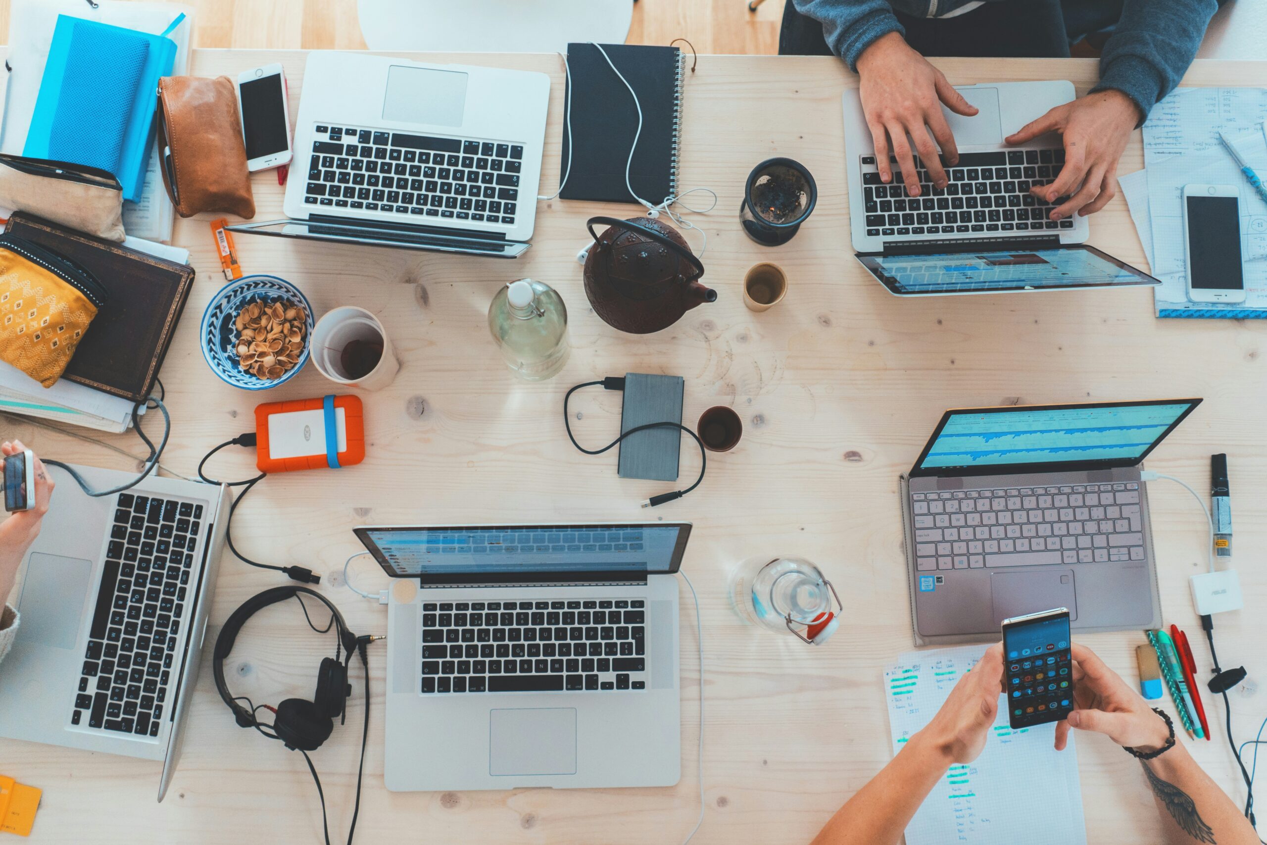A team working together at a shared table of laptops